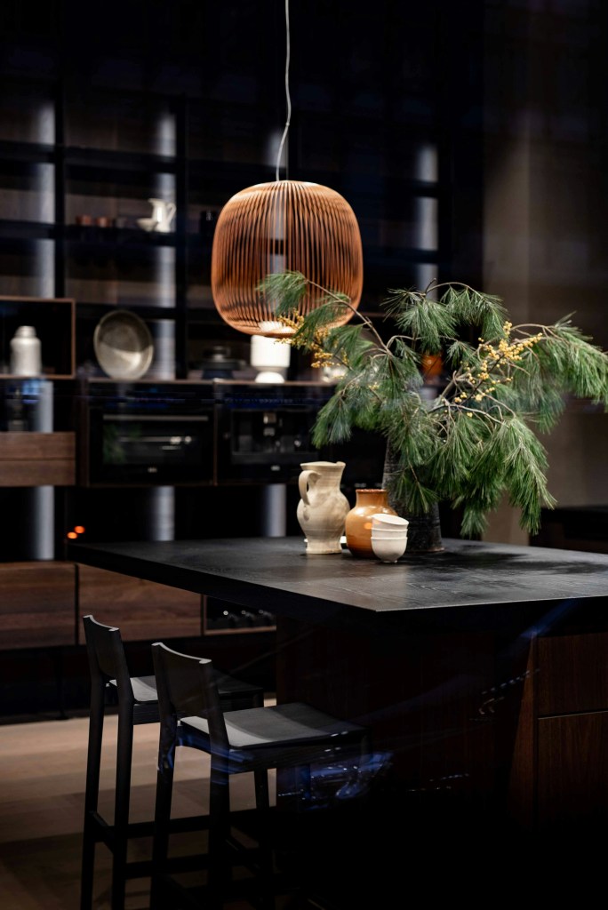 Minimalist kitchen decorated with wooden elements, greenery, and ceramic vases to highlight natural materials.