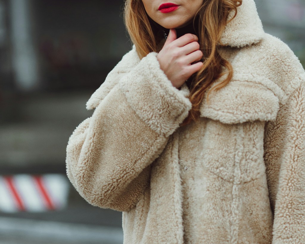 woman wearing beige teddy coat winter outfit close up with cozy scarf styling