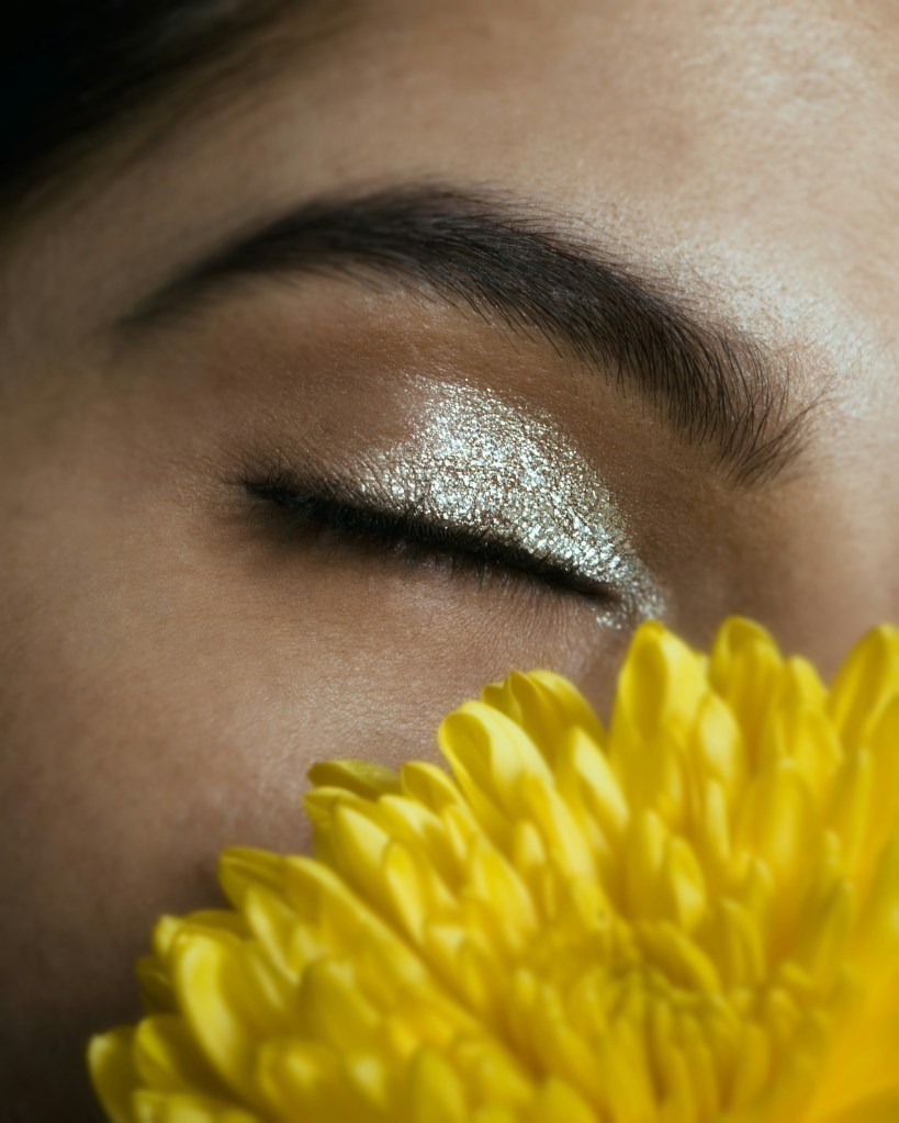 Close-up eye makeup with feathered natural brows and metallic shimmer eyeshadow.