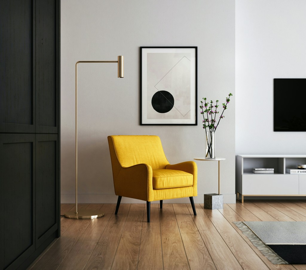 Minimalist living room with a bold yellow statement chair, modern wall art, and clean neutral decor.