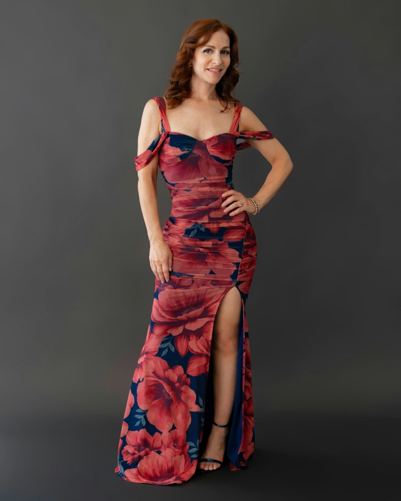 Model in a red floral cold-shoulder gown, highlighting the winter 2025 floral fashion trend.