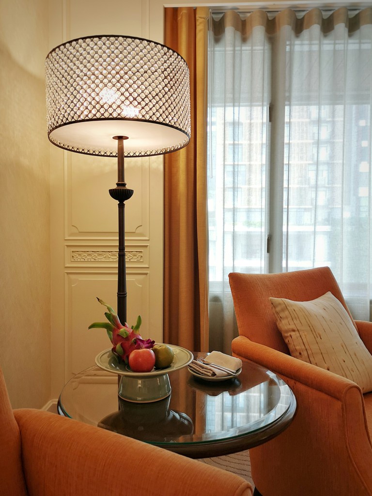 Warm oversized floor lamp creating a cozy winter living room with soft lighting and neutral seating.