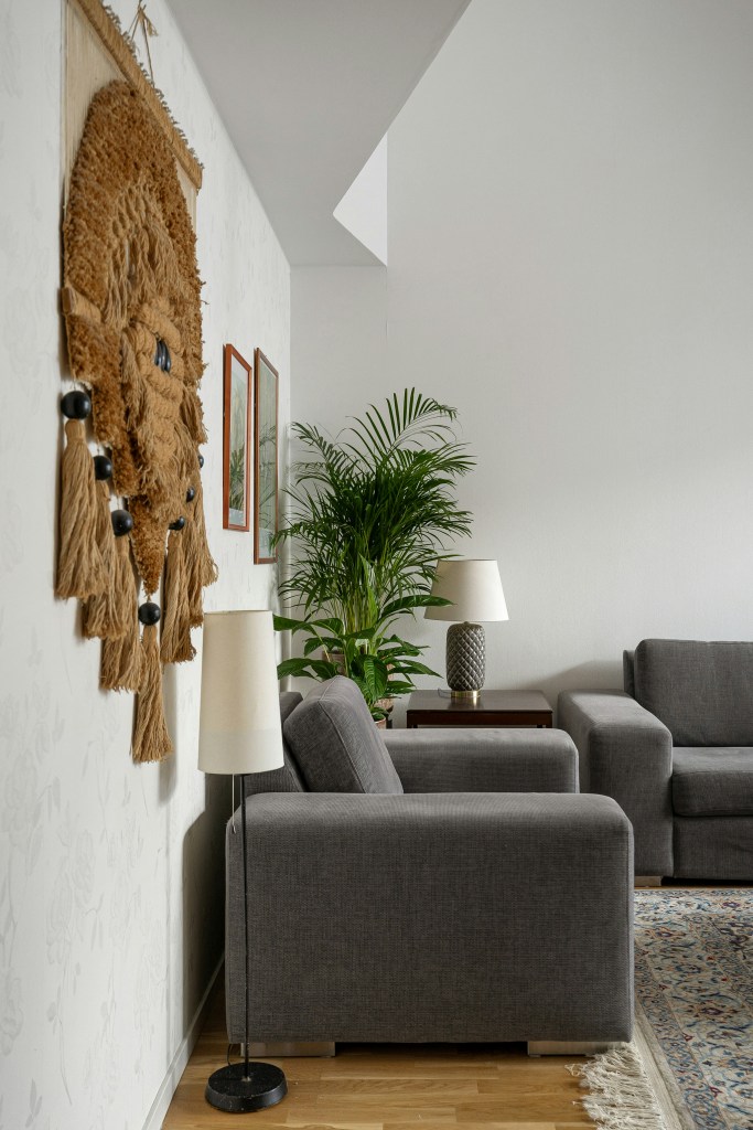 Cozy winter entryway styled with textured wall decor, greenery, and inviting neutral furnishings.