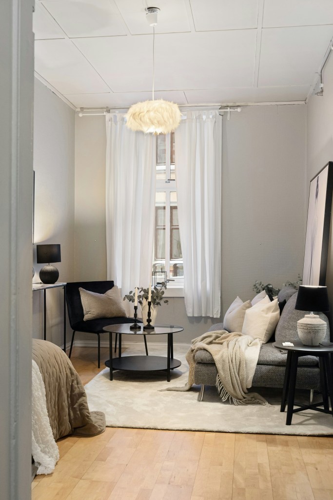 Layered sheer curtains in a cozy winter living room designed to retain warmth and soften natural light.