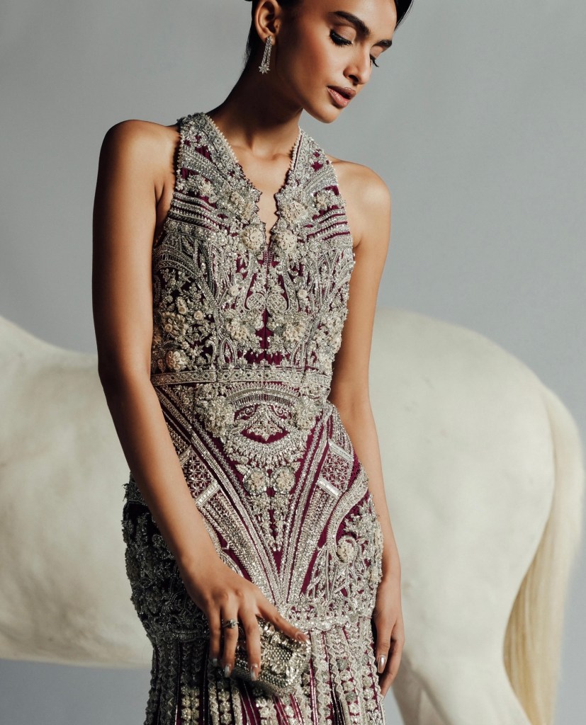 Maroon and silver heavily embellished bridal gown featuring intricate beadwork and embroidery in a couture silhouette.