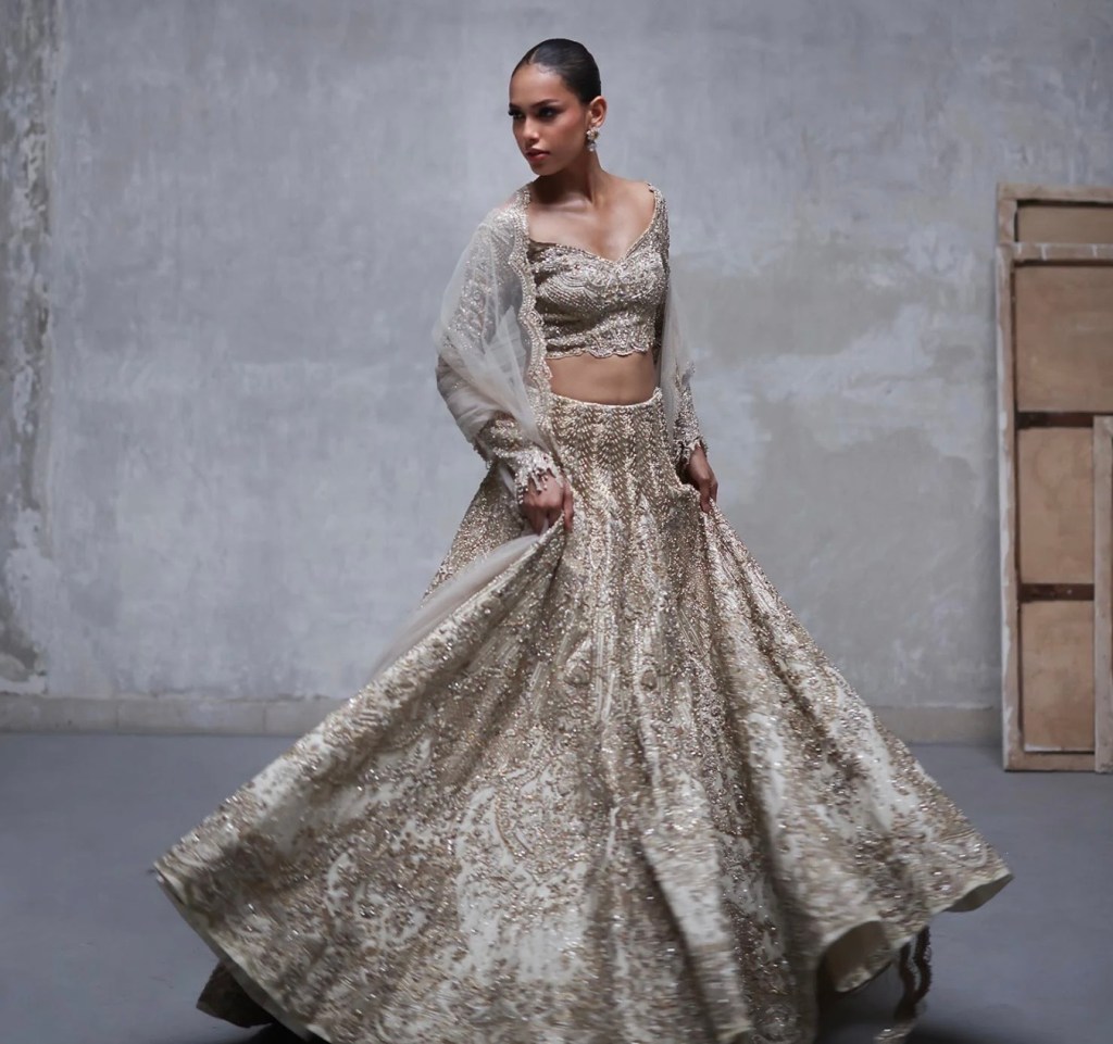 Silver bridal lehenga with intricate beadwork captured in motion, highlighting shimmer, texture, and couture detailing.