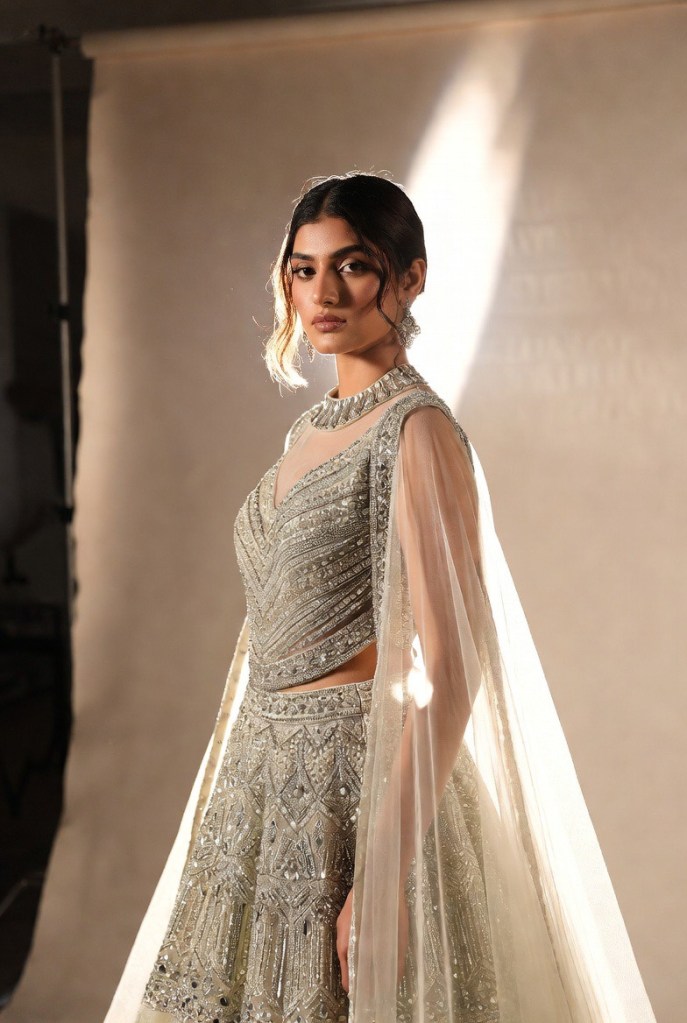 Modern silver lehenga featuring detailed embroidery and a flowing detachable overskirt, designed for versatile bridal styling.