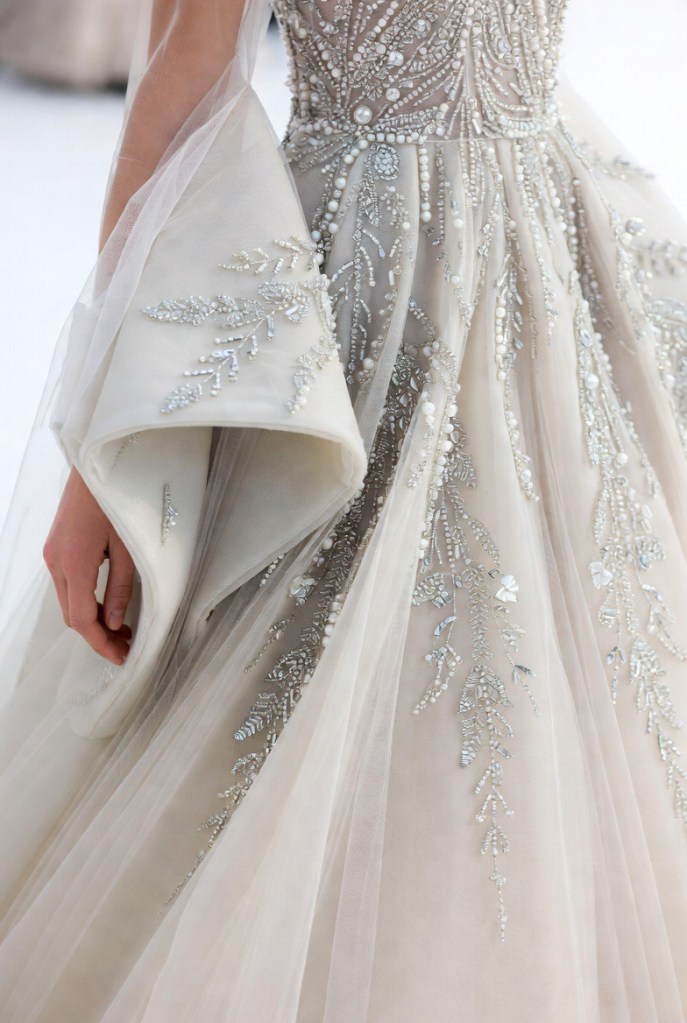 Close-up of silver beadwork embroidery on a bridal lehenga with sheer layered overskirt detailing.